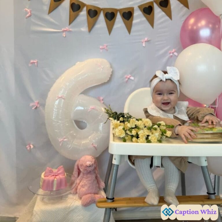 A joyful baby girl sitting in a high chair, surrounded by balloons, flowers, and a large '6' balloon.