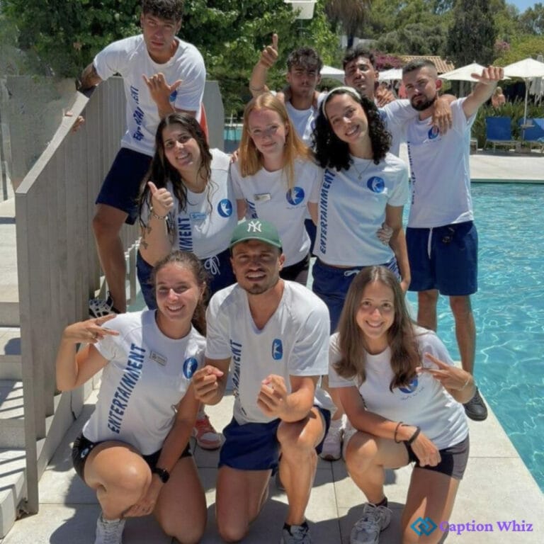 A group of ten young adults posing together by a pool, all wearing matching white shirts.